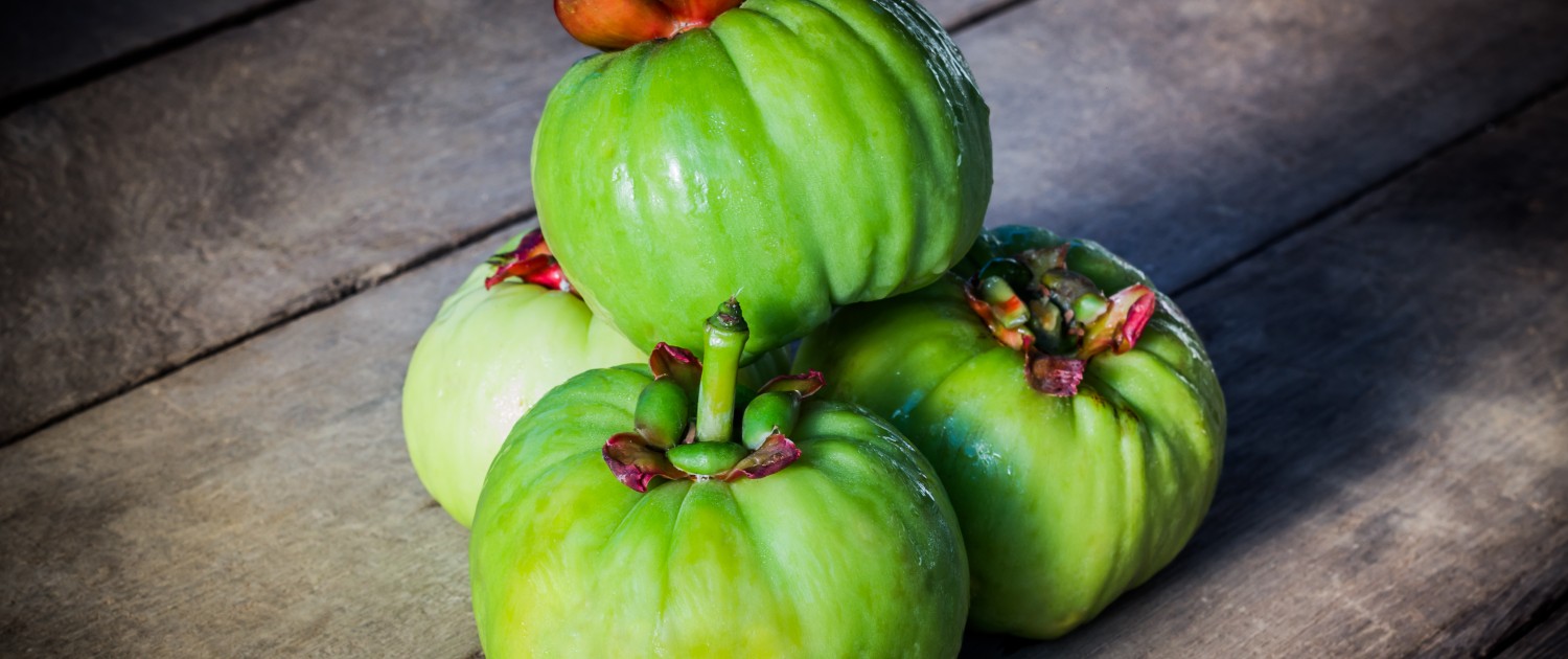 Still life with fresh garcinia cambogia on wooden background (Th