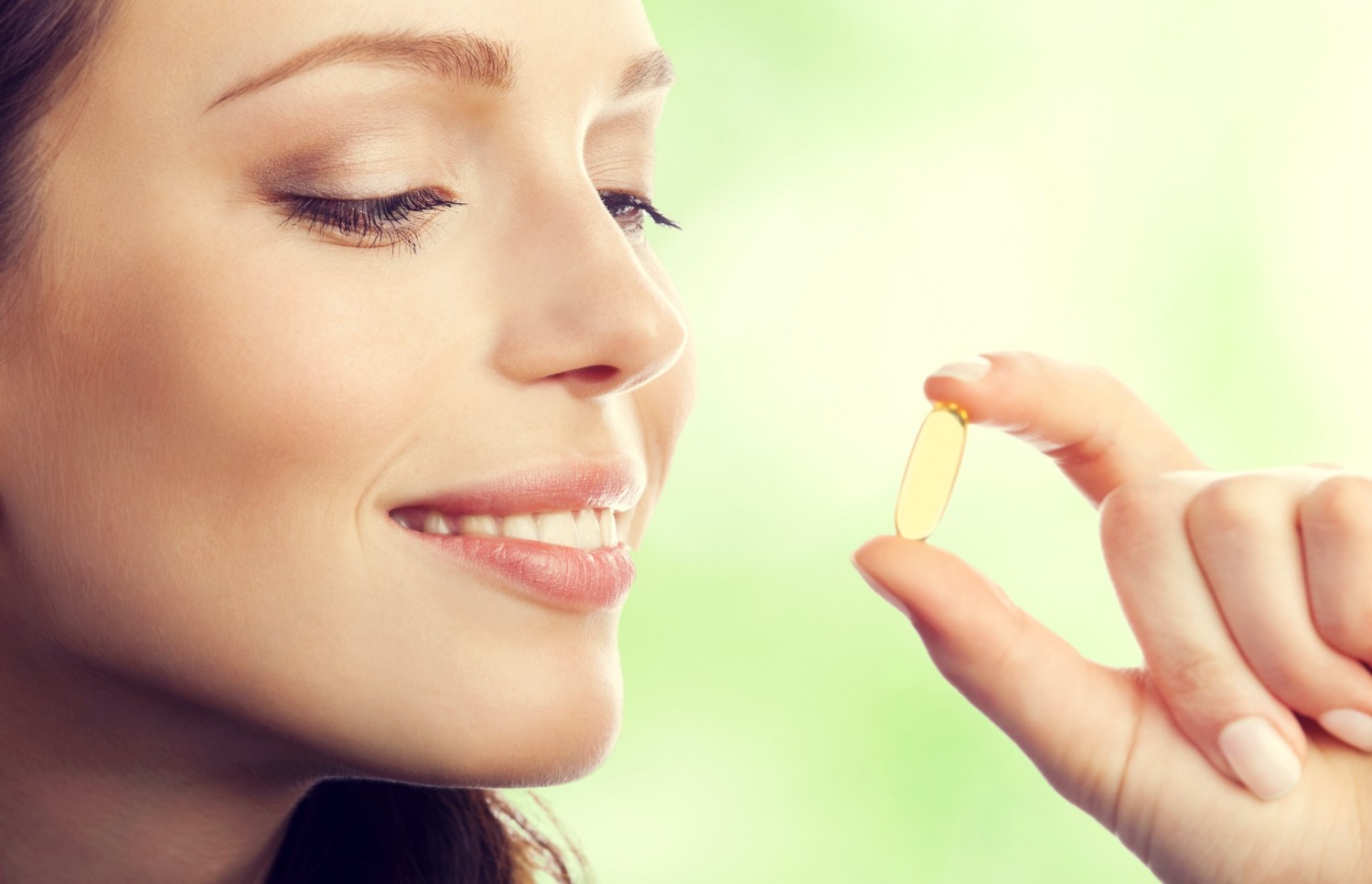 BM_Woman showing Omega 3 fish oil capsule_87990115