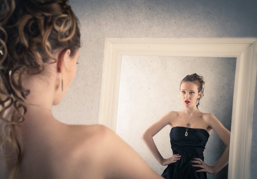 BM_Girl looking at herself into the mirror_72627007