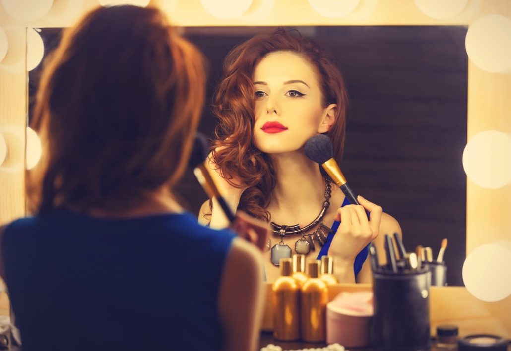 BM_Portrait of a beautiful woman as applying makeup near a mirror_75935787
