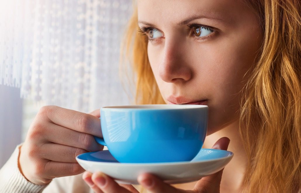 BM_Beautiful woman sipping coffee from her cup_81555486
