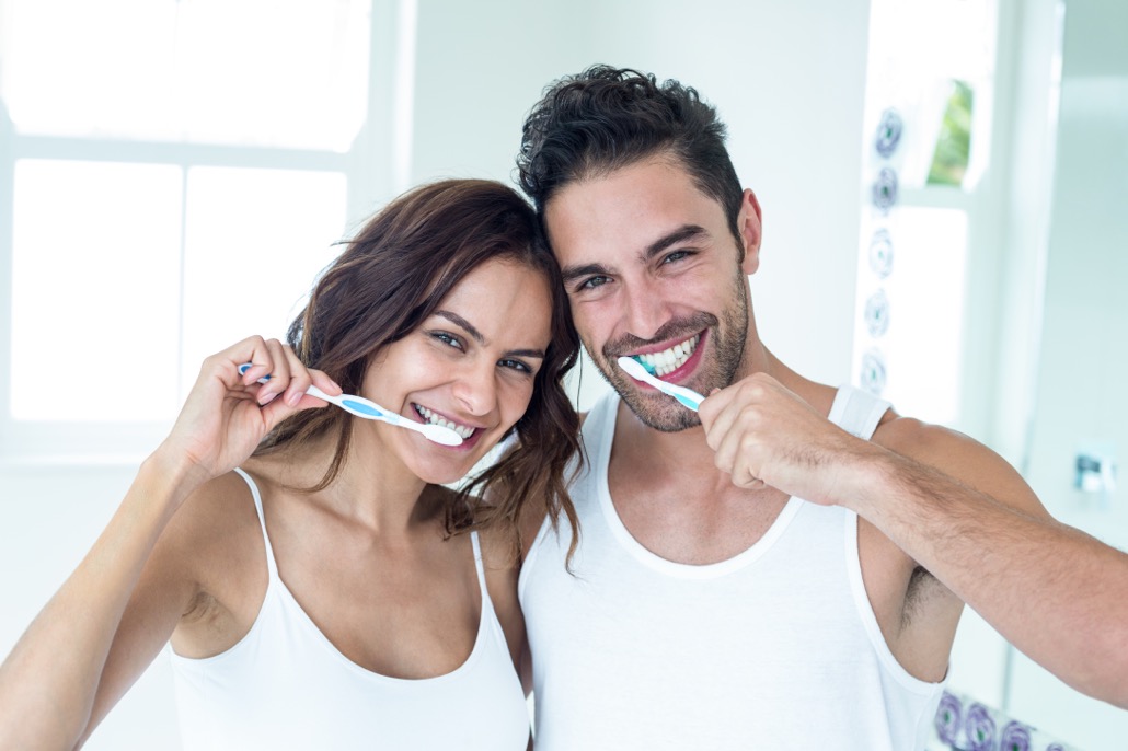 BM_Happy couple brushing teeth in bathroom_107925902